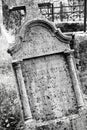 Old weathered crooked  Christian Catholic tombestone at  graveyard in black and white Royalty Free Stock Photo