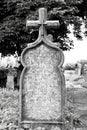 Old weathered crooked  Christian Catholic tombestone at  graveyard in black and white Royalty Free Stock Photo