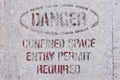 Old weathered Danger, Confined Space Entry Permit Required warning sign spray painted on metal background Royalty Free Stock Photo