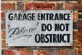 Old weathered do not obstruct sign on worn old brick wall