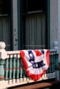 Old,weathered exterior of home with American flag draped over railing Royalty Free Stock Photo