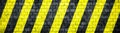 Old and weathered grungy brick wall with danger or attention black and yellow warning diagonal stripes texture background banner