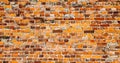 Old and weathered grungy yellow and red brick wall as seamless pattern texture surface background in wide banner format Royalty Free Stock Photo