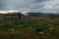 old weathered houses on field with tall grass and stones, Norway, Hardangervidda Royalty Free Stock Photo