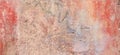 Old weathered painted wall background texture. Red dirty peeled plaster wall with falling off flakes of paint. Royalty Free Stock Photo