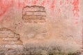 Old weathered painted wall background texture. Red dirty peeled plaster wall with falling off flakes of paint. Royalty Free Stock Photo