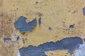 Old weathered painted wall background texture . Yellow dirty peeled plaster wall with falling off flakes of paint Royalty Free Stock Photo