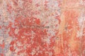 Old weathered painted wall background texture. Red dirty peeled plaster wall with falling off flakes of paint. Royalty Free Stock Photo