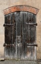 Old weathered rotten wooden dark door in a n old brick wall. Royalty Free Stock Photo