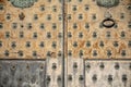 Old and time-worn solid wooden door with decorative metal elements Royalty Free Stock Photo