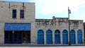 Old weathered stone building with bright blue iron gates and doorways, Austin, Texas, 2018