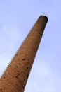 Old weathered tall industrial factory chimney, red grungy brick smokestack perspective Royalty Free Stock Photo