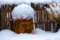 Old weathered terracotta buddha head covered with snow