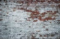 Old weathered vintage brick wall partially painted white