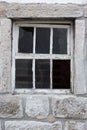 Old weathered window in a massive stone wall Royalty Free Stock Photo