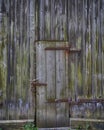 Old weathered wooden barn door with steel hinges Royalty Free Stock Photo