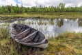 Old and weathered wooden boat wreck laying on the ground in beautiful norwegian landscape with mountains in the background