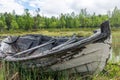 Old and weathered wooden boat wreck laying on the ground in beautiful norwegian landscape