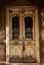 Old weathered wooden door on a crumbling stone wall of a building.