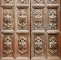 Old weathered wooden ornate on vintage weathered door. Details of antique artisan scratched wood surface. Italian architecture