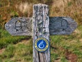 An old, weathered wooden sign indicating the route of the Wales Coast Path in Pembrokeshire, Wales, UK Royalty Free Stock Photo