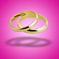 old wedding rings floating against pink background Royalty Free Stock Photo