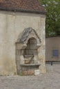 Old well against a cream coloured wall Royalty Free Stock Photo