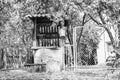 Old well with iron bucket on long forged chain for clean drinking water Royalty Free Stock Photo