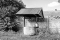 Old well with iron bucket on long forged chain for clean drinking water Royalty Free Stock Photo