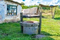Old well with iron bucket on long forged chain for clean drinking water Royalty Free Stock Photo