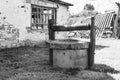 Old well with iron bucket on long forged chain for clean drinking water Royalty Free Stock Photo