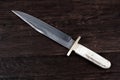 Old west bowie knife on wooden deck