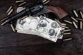 Old west Colt Peacemaker and US banknotes and silver certificates with silver dollar coins and .45 caliber revolver ammunitions