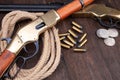Old west gun - lever-action repeating rifle with ammunition and silver dollar coins