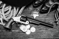 Old west law enforcement - revolver gun with marshal badge and silver dollars with hat, rope and cowboy boots