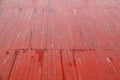 An old wet wooden pavement painted in red on a rainy day. Photo in perspective