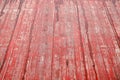 An old wet wooden pavement painted in red on a rainy day. Photo in perspective