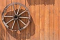 Old wheel from a cart on a wooden wall Royalty Free Stock Photo