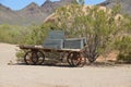 Old wheel supporting a rotting weathered dynamite wood wagon