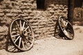 Old wheel from vintage cart beside wall Royalty Free Stock Photo