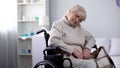 Old wheelchaired woman sleeping in rehabilitation center, having nap, health