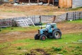 Old wheeled tractor near the fence of a livestock farm Royalty Free Stock Photo