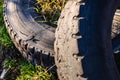 Old wheels of unrecycled cars thrown in a natural field pollute the earth Royalty Free Stock Photo