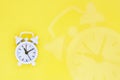 Old white alarm clock on a yellow background, flat lay. Top view. Concept of time, timer, countdown Royalty Free Stock Photo