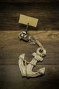 Old white anchor with wooden squid shape clip and blank piece of paper Royalty Free Stock Photo