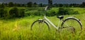 Old white bike parked in the meadow on the mountain.Behind the Royalty Free Stock Photo