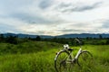 Old white bike parked in the meadow on the mountain.Behind the Royalty Free Stock Photo