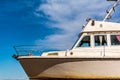 Old white boat shot sidewise against blue sky