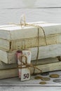 Old white books with money and coins on wooden background Royalty Free Stock Photo