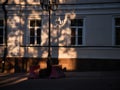 An old white building and a street lamp at sunset. Evening